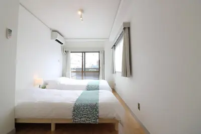 a bedroom with two beds and a window at Senkawa CV House SC1 in Tokyo