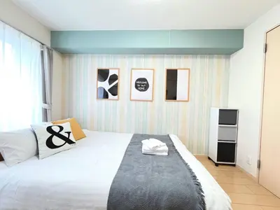 a bedroom with a large bed and some pictures on the wall at Belle Vie Waseda BW32 in Tokyo