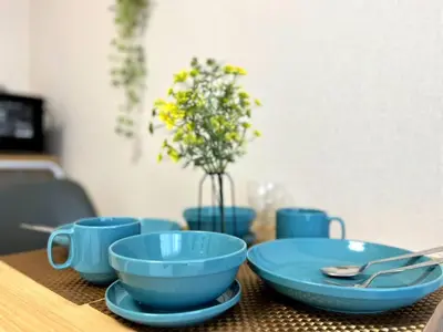 a table with blue bowls and a vase with flowers at Belle Vie Waseda BW32 in Tokyo