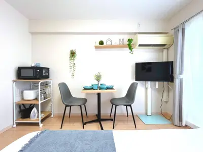 a living room with a table and chairs and a tv at Belle Vie Waseda BW32 in Tokyo