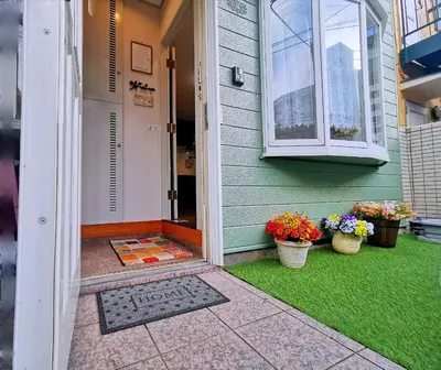 a front door of a house with two potted plants at \u5c71\u624b\u7dda\u99c5\u5f92\u6b694\u5206\u5bb6\u65cf\u9023\u308c\u306b\u6700\u9069\u306a\u65b0\u5bbf\u76ee\u767d\u30ac\u30fc\u30c7\u30f3\u30cf\u30a6\u30b9\u4e00\u68df\u8cb8\u5207\u5e8a\u6696\u623f\u4ed8\u304d in Tokyo