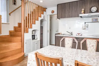 a kitchen with a dining table and a stairway at \u5c71\u624b\u7dda\u99c5\u5f92\u6b694\u5206\u5bb6\u65cf\u9023\u308c\u306b\u6700\u9069\u306a\u65b0\u5bbf\u76ee\u767d\u30ac\u30fc\u30c7\u30f3\u30cf\u30a6\u30b9\u4e00\u68df\u8cb8\u5207\u5e8a\u6696\u623f\u4ed8\u304d in Tokyo