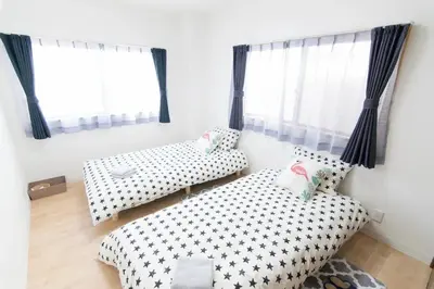 a bedroom with two beds and windows with curtains at SY-HOTEL Kuramae 5mins \u673a\u573a\u76f4\u8fbe \u4ea4\u901a\u4fbf\u5229 \u8535\u524d5\u5206\u949f in Tokyo