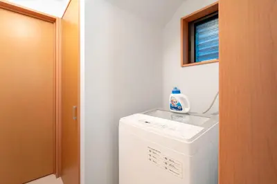 a laundry room with a washing machine and a window at \u5317\u6c60\u888b\u6238\u5efa in Tokyo
