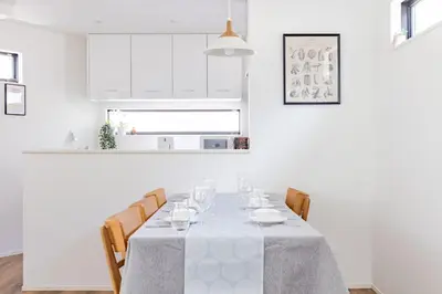 a white dining room with a table and chairs at First Choice in Tokyo