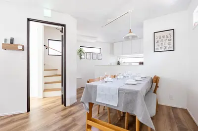 a white dining room with a table and chairs at First Choice in Tokyo