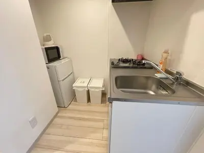 a small kitchen with a sink and a refrigerator at COMMA HOUSE Nishi-Ikebukuro 3F in Tokyo