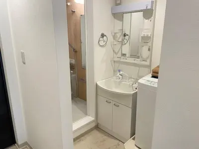 a white bathroom with a shower and a sink at COMMA HOUSE Nishi-Ikebukuro 3F in Tokyo