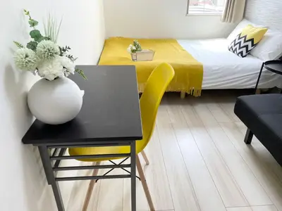 a small room with a table and a bed at COMMA HOUSE Nishi-Ikebukuro 3F in Tokyo