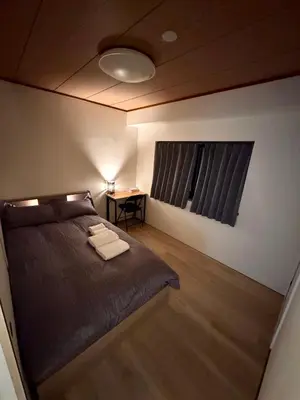 a bedroom with a bed and a table with a lamp at \u4ea4\u901a\u4fbf\u5229\u65b0\u5bbf\u79cb\u8449\u539f\u76f4\u901a in Tokyo