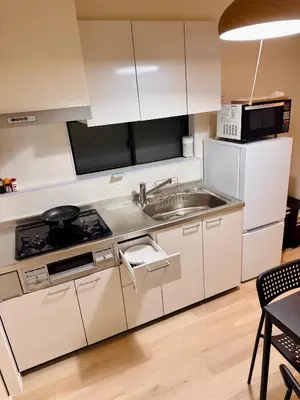 a kitchen with white cabinets and a sink and a stove at \u4ea4\u901a\u4fbf\u5229\u65b0\u5bbf\u79cb\u8449\u539f\u76f4\u901a in Tokyo