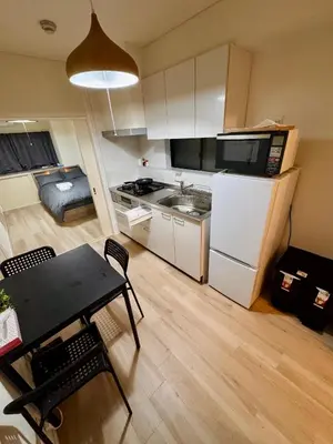 a small kitchen with a table and a refrigerator at \u4ea4\u901a\u4fbf\u5229\u65b0\u5bbf\u79cb\u8449\u539f\u76f4\u901a in Tokyo