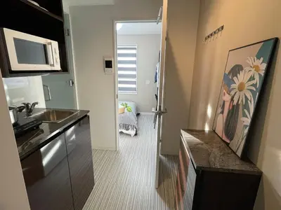a small kitchen with a sink and a microwave at COMMA HOUSE Shinjuku 2UNITS 2122 in Tokyo