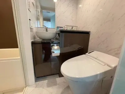 a bathroom with a white toilet and a sink at COMMA HOUSE Shinjuku 2UNITS 2122 in Tokyo