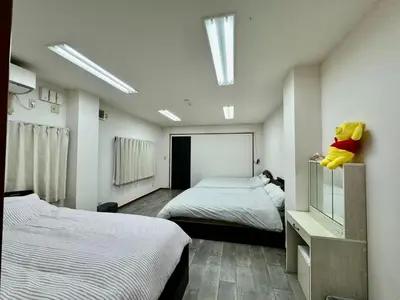 a bedroom with two beds and a stuffed animal on a shelf at Kobayashi Building - Vacation STAY 82335v in Tokyo