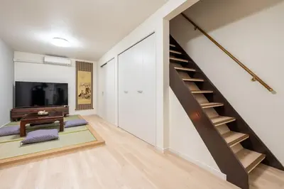a living room with a staircase and a tv at \u65e5\u672c\u5bb6\u5c4b\u6c11\u6cca in Tokyo