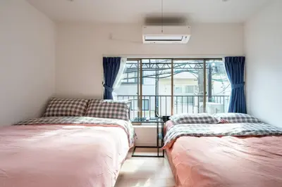 two beds in a room with a window at \u65e5\u672c\u5bb6\u5c4b\u6c11\u6cca in Tokyo