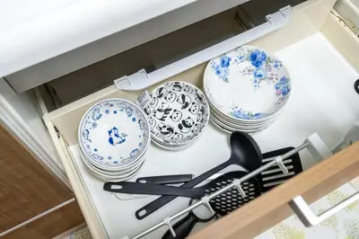 a drawer filled with blue and white plates and a whisk at \u65e5\u672c\u5bb6\u5c4b\u6c11\u6cca in Tokyo