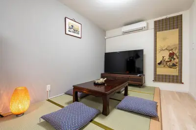 a living room with a table and a flat screen tv at \u65e5\u672c\u5bb6\u5c4b\u6c11\u6cca in Tokyo