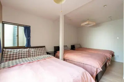 a bedroom with two beds and a window in it at \u65e5\u672c\u5bb6\u5c4b\u6c11\u6cca in Tokyo