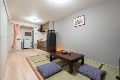 a living room with a table and a kitchen at \u65e5\u672c\u5bb6\u5c4b\u6c11\u6cca in Tokyo