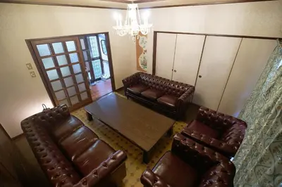 a living room with leather furniture and a table and chairs at yoyogi house jellyne in Tokyo
