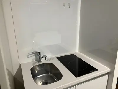 a small kitchen with a sink in a cabinet at HW HILLS Komagome 101 by Tranova in Tokyo