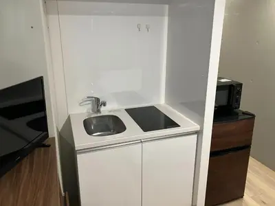 a small kitchen with a sink and a microwave at HW HILLS Komagome 101 by Tranova in Tokyo
