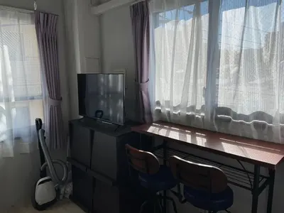 a room with a desk with two chairs and a television at HW HILLS Komagome 401 by Tranova in Tokyo