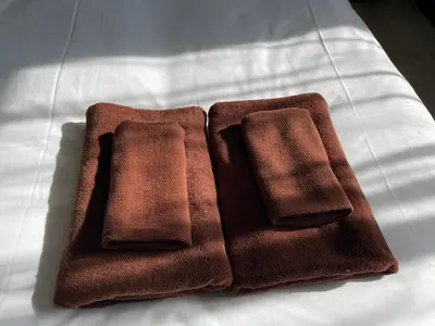 two brown towels sitting on top of a bed at HW HILLS Komagome 401 by Tranova in Tokyo