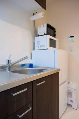 a kitchen with a sink and a white refrigerator at Craft202 \u6d45\u8349 \u30b9\u30ab\u30a4\u30c4\u30ea\u30fc\u8fd1\u304f \u6771\u4eac\u89b3\u5149\u306b\u6700\u9069 \u7a7a\u6e2f\u304b\u3089\u30a2\u30af\u30bb\u30b9\u826f\u597d \u7121\u6599WiFi in Tokyo
