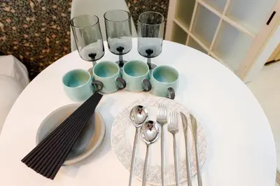 a white table with silverware and wine glasses on it at Kimura House by Tranova in Tokyo