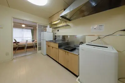 a kitchen with a refrigerator and a table in it at Kimura House by Tranova in Tokyo
