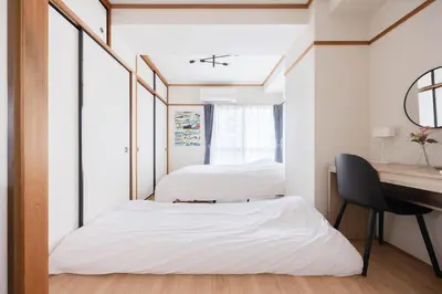 two beds in a room with a desk at Tokyo Kitasen 4 in Tokyo
