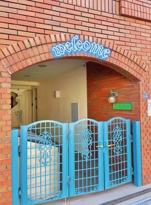 a brick building with a blue gate in front at Easily to Nishi-Nippori Shibuya Asakusa For 10 in Tokyo