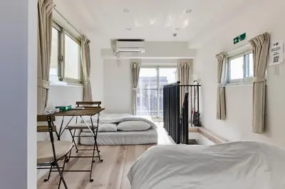 a bedroom with two beds and a desk in it at New\u6771\u4eac\u3067\u5bcc\u58eb\u5c71\u304c\u898b\u3048\u308bPentohouse ZEN \u5965\u6ca2\u99c51\u5206\u81ea\u7531\u30f6\u4e18\u5f92\u6b696\u5206\u6e0b\u8c37\u96fb\u8eca15\u5206 in Tokyo