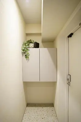 a white cabinet with a potted plant on it at GIVE Meidaimae in Tokyo