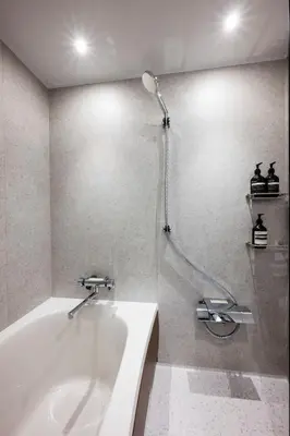 a bathroom with a white tub and a shower at GIVE Meidaimae in Tokyo