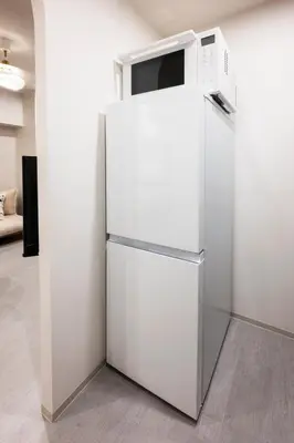 a white refrigerator with a microwave on top of it at GIVE Meidaimae in Tokyo