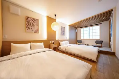 a hotel room with two beds and a window at Tokyo Modern Stay Shinjuku in Tokyo