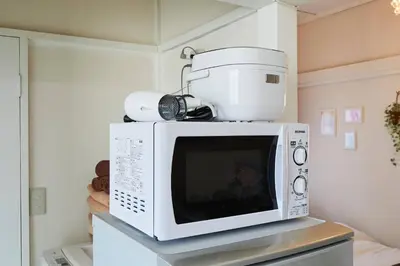 a microwave with a coffee maker on top of it at Okubo Daiichi House2C OD2C in Tokyo