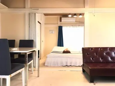a bedroom with a bed and a table and a window at Okubo Daiichi House 1B OD1B in Tokyo