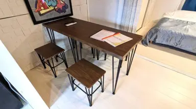 a table with two stools and a bed in a room at Okubo Daiichi House 1B OD1B in Tokyo
