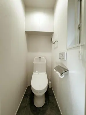 a bathroom with a toilet and a toilet paper dispenser at cityhouse\u6c60\u888b in Tokyo