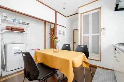 a kitchen with a table with a vase of flowers on it at Chelsea Hatsudai 201 CH21 in Tokyo