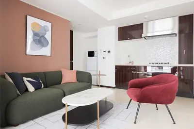 a living room with a green couch and a red chair at \u30e9\u30b9\u30d1\u30b7\u30aa\u9ebb\u5e03\u7b04\u753a\u30ec\u30b8\u30c7\u30f3\u30b9 in Tokyo
