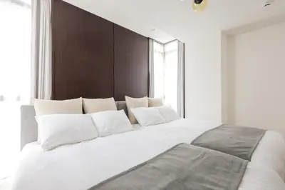 a bedroom with a large white bed with white pillows at \u30e9\u30b9\u30d1\u30b7\u30aa\u9ebb\u5e03\u7b04\u753a\u30ec\u30b8\u30c7\u30f3\u30b9 in Tokyo