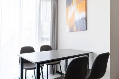 a dining room table with chairs and a painting on the wall at \u30e9\u30b9\u30d1\u30b7\u30aa\u9ebb\u5e03\u7b04\u753a\u30ec\u30b8\u30c7\u30f3\u30b9 in Tokyo