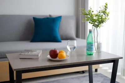 a coffee table with a bowl of fruit and a bottle at Noble Park RYOGOKU in Tokyo