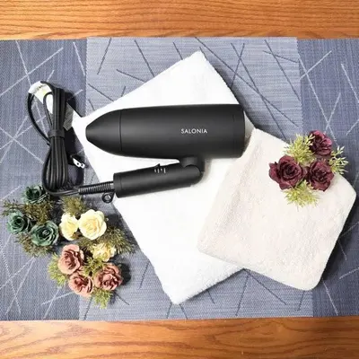 a black hair dryer sitting on a table with flowers at Walk to World Athletics! Prime Omotesando 2min sta in Tokyo
